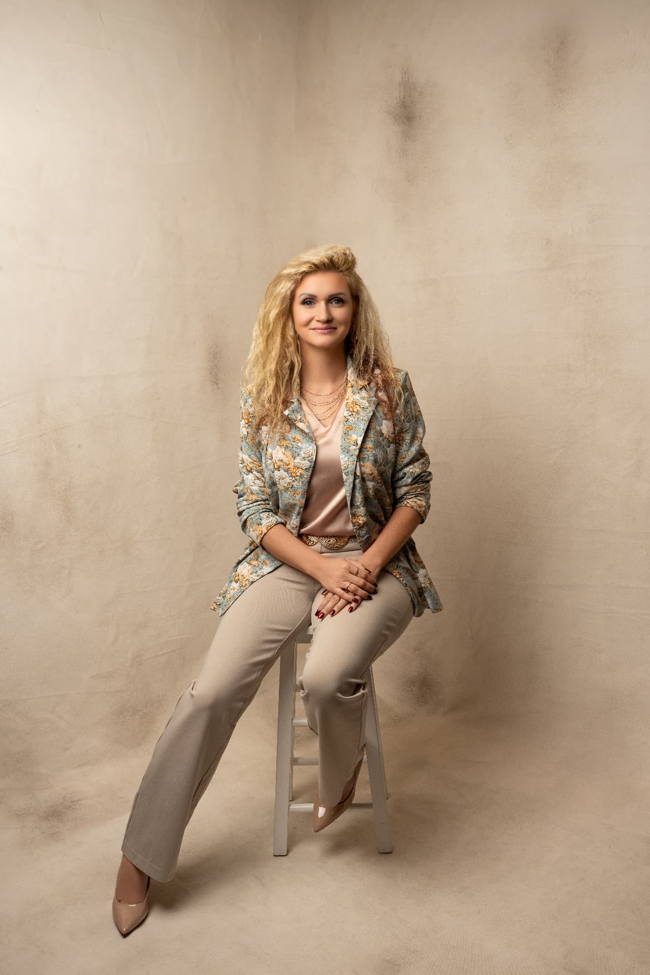 Red Gamso seated confidently in a floral blazer